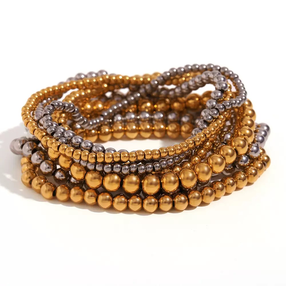 Rhea layered gold and silver stainless steel beaded stretch bracelet set featuring polished stackable bead bracelets for everyday elegance. Luxury gold and silver beaded bracelet stack by KemisJewel. 