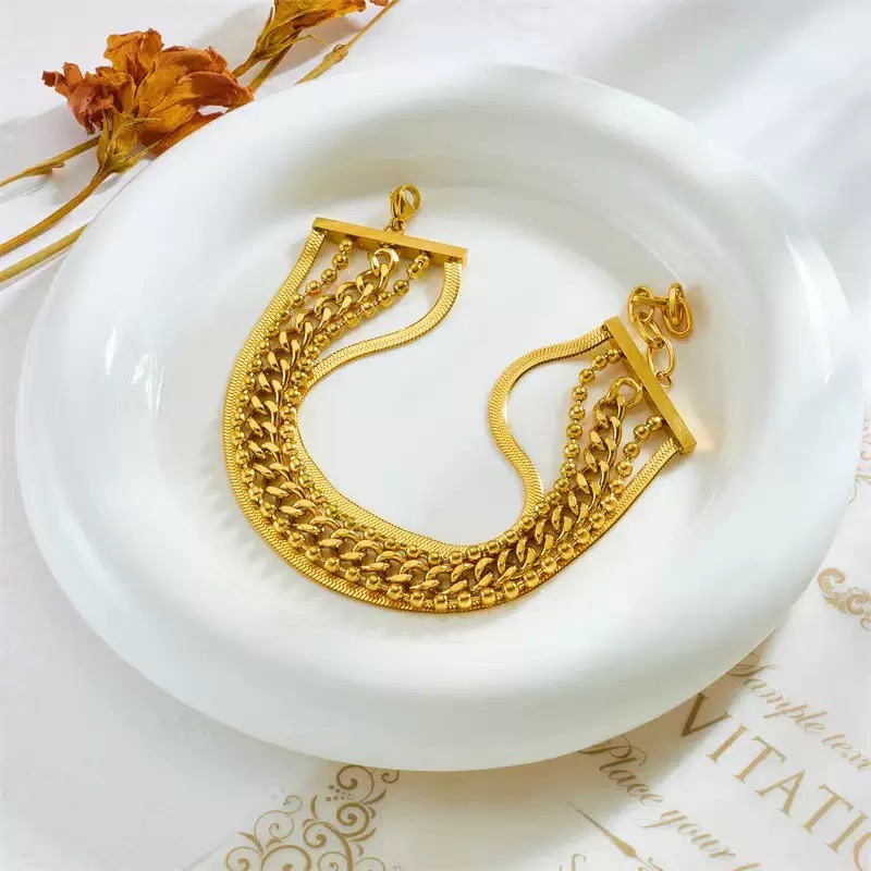 Luxury gold layered chain bracelet by KemisJewel. Gold plated stainless steel bracelet featuring mixed chain styles. Elegant multi-layer bracelet with snake and curb chain detailing.
