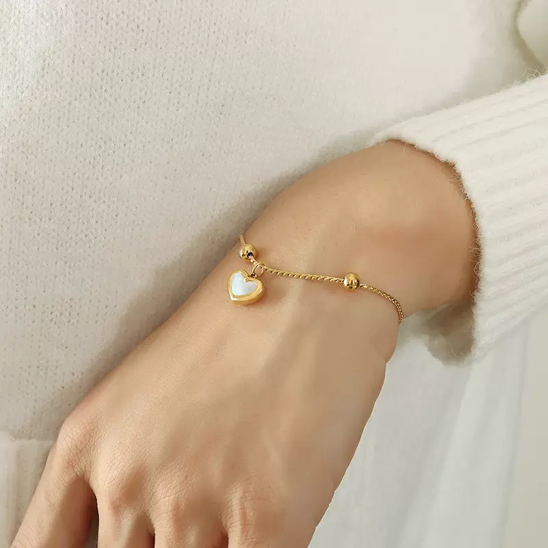 Pearce™ 18K gold plated stainless steel adjustable bracelet featuring a delicate mother of pearl heart charm on a fine twisted chain.